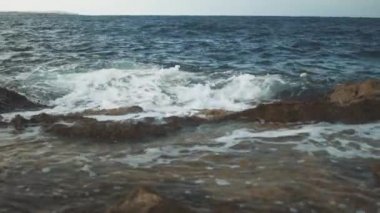 Dalgalar kayalık kıyıya vuruyor.