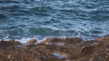 Beyaz gelgit kazasında taşlar ve şekillendirme deniz köpüğü karşı.