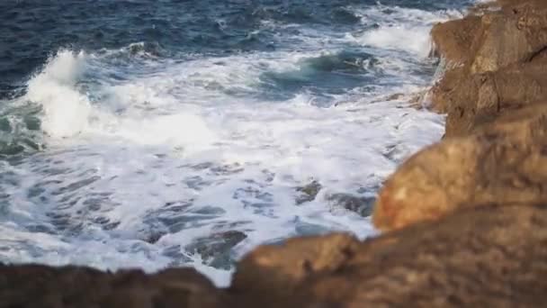 Marés brancas colidem contra as pedras e formando espuma do mar . — Vídeo de Stock