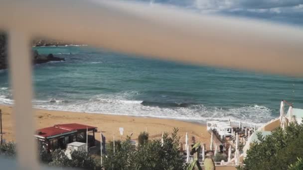 Удивительный вид на песчаный пляж на острове в Средиземном море. Облака дождя над морем и средиземноморский город, стоящий на небольшой скалистой скале . — стоковое видео