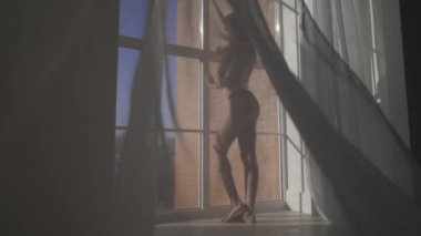 Genç seksi çıplak kadın kat tavan üzerinden tül penceresinden yakınındaki poz uzun kahverengi saçlı. Kız Külot içinde kusursuz bir beden ile. Kadın iç çamaşırı kıçından.