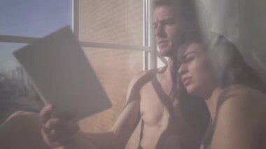 Güzel seksi çıplak kadın uzan genç çıplak sarışın ile dostum tül pencereden yakınındaki bir kitap okuyan. Erkek yüzüne gözyaşları var.