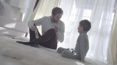 Halı oğluyla oturuyor ve para tutan oynak baba. Adam ve çocuk bir parmak için burun koymak. Baba ile çocuk kabul eder. Baba-oğul ilişkisi.