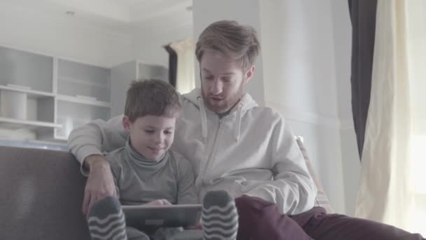 Volwassen man imiteert verrassing door de acties van zijn zoon. Jongen is vrolijk en lachend. Gelukkige familie tijd samen doorbrengen. Vader-zoon relatie. — Stockvideo