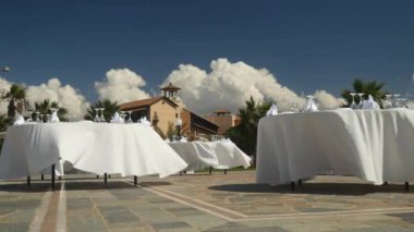 Açık hava partisi için hazırlık: şampanya bardağı ve peçeteler yuvarlak masa üzerinde beyaz masa örtüsü süslemeleri