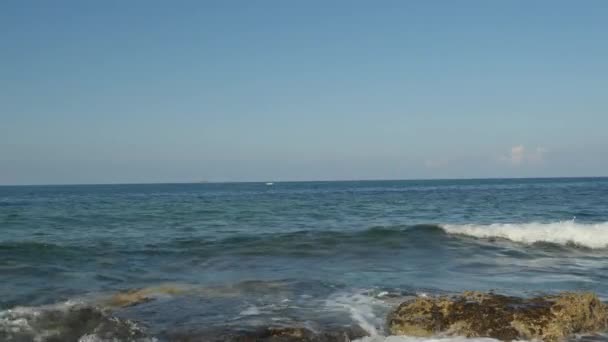 Reggeli kilátás szép nyári nap Cipruson. Hab sima hullámok beat sziklák, tiszta víz, tiszta horizontot. — Stock videók