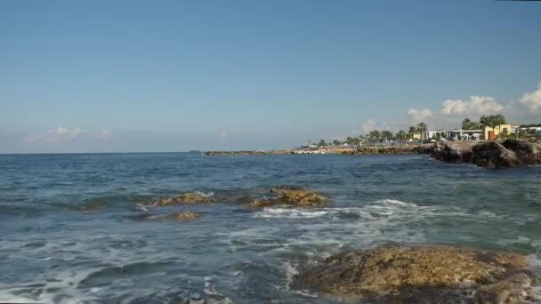 Неспокійним море на Кіпрі. Хвиль, викликаних на камені, створюючи морській піні. Мальовничий вид на невеликий острів — стокове відео