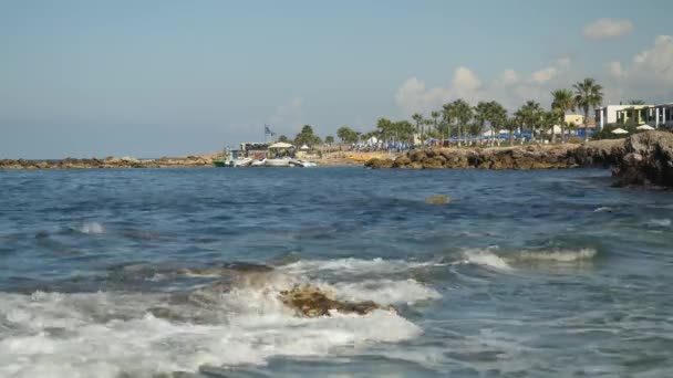 Unruhige See in Zypern. Wellen, die auf Steine krachen und Meeresschaum erzeugen. malerischer Blick auf kleine Insel. — Stockvideo