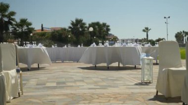 Açık hava partisi için hazırlık: şarap ve şampanya bardakları ve peçeteler büyük masada beyaz masa örtüsü süslemeleri