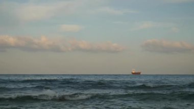 Küçük yük gemi yelken çalkantılı deniz kenarında, büyük dalgalar sıçrama taşı, kapak ve köpük oluşturmak