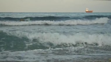 Küçük yük gemi yelken çalkantılı Kıbrıs deniz kenarında, büyük dalgalar sıçrama taşı, kapak ve köpük oluşturmak