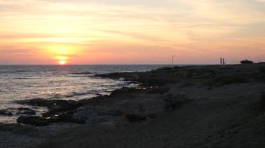Akdeniz Beach güzel renkli gün batımı. Yalnız araba manzara seyretmek için güzel pitoresk yerde park etmiş. Zaman sukut.