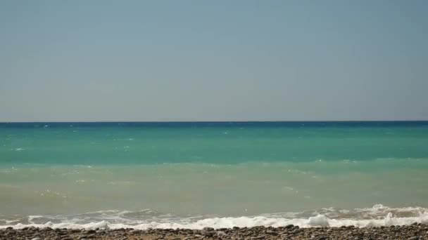 Ruhige Zeitraffer von kleinen Wellen, die einen leeren Strand zum Schäumen bringen. Sommertag an der zyprischen Küste. — Stockvideo