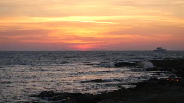 Belo pôr do sol colorido na praia do mar Mediterrâneo. Navio solitário velejar por água ondulante bonita — Vídeo de Stock