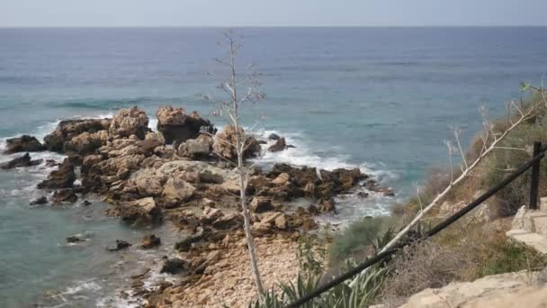 Vista de la mañana en la playa rocosa. Las olas del mar Mediterráneo chocan contra las piedras creando espuma blanca y burbujas. Vueltas de tiempo — Vídeo de stock
