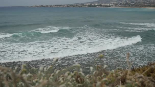 Schiuma enorme che crea da acqua cristallina blu sulla costa del Mar Mediterraneo sullo sfondo paesaggio della città . — Video Stock