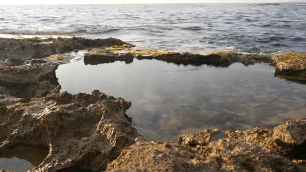 Hermosas rocas minerales forman aguas poco profundas en las que las olas del mar Mediterráneo se estrellan creando grandes salpicaduras y espuma — Vídeo de stock