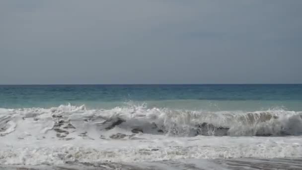 Onde schiumose rotolano sulla costa. Schiuma creata dall'acqua blu sulla costa mediterranea . — Video Stock
