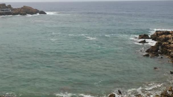 Morgenblick auf den felsigen Strand. Mittelmeerwellen krachen gegen Steine und erzeugen weißen Schaum und Blasen. — Stockvideo