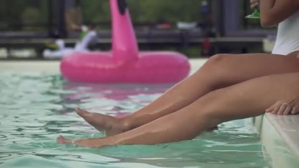 Štíhlé štíhlé ženy štíhlé nohy vytvářet obrovské vody ve venkovním bazénu. Volný čas a zábava dívky. — Stock video