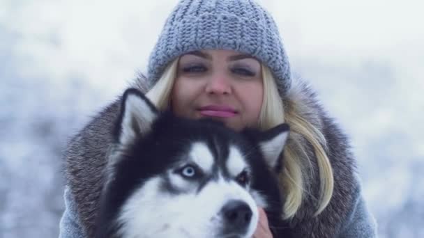 Piękna Młoda Kobieta Gospodarstwa Przytulanie Puszysty Siberian Husky Tle Śniegu — Wideo stockowe