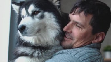 Pencereden dışarı bakıp, onun düşüncelerle ve rüya üzerinde husky elele yakışıklı güleryüzlü adam portresi
