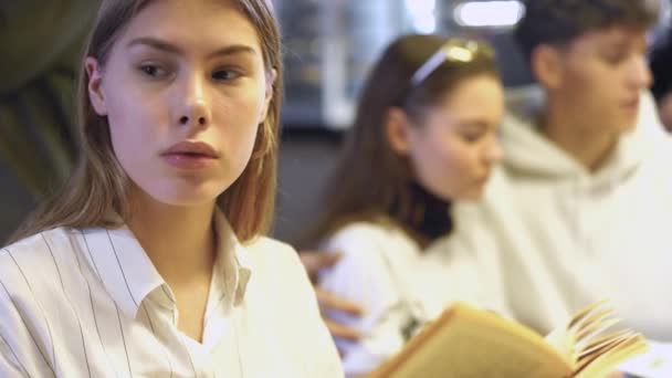 Genç kız bir kafede bir kitap okuma yorgun ve kolunda yaslanmış bir şekerleme almaya karar verdi. — Stok video