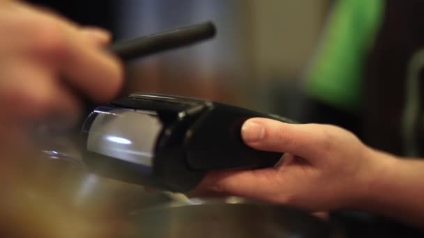 Gros plan de la main masculine utilisant le paiement mobile au restaurant pour payer la nourriture et les boissons — Video