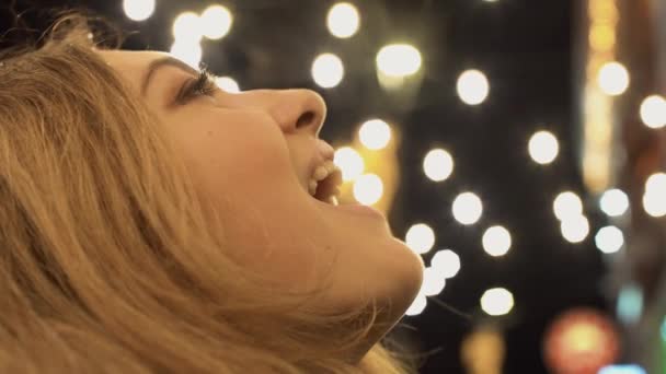 Счастливая красивая женщина играет на открытом воздухе, пытаясь поймать снежинки языком близко — стоковое видео