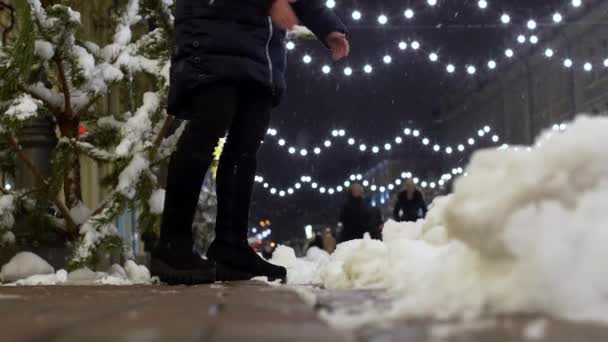 Vrouwelijke benen schoppen de sneeuw buiten in de straat. Winterpret van jonge vrouw — Stockvideo