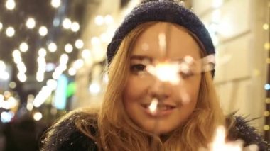 Elinde havai fişekleri ile neşeli güzel kadın portresi yakından kapatın. Sparks Scatter farklı yönlere