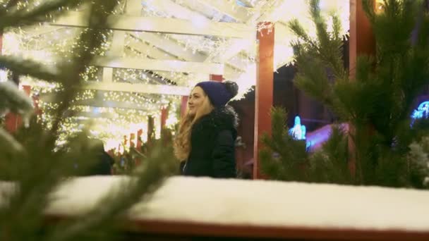 年轻女子欣赏街上的圣诞灯光 女性在户外看咖啡馆的装饰 穿着温暖的冬装的女士抬头 — 图库视频影像