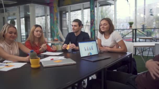 Nuorten menestyneiden liikemiesten ryhmä kokoontuu neuvottelupöytään keskustelemaan taloudellisesta raportista . — kuvapankkivideo