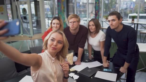 Un team creativo che si fa un selfie su uno smartphone dopo aver completato un incarico o un progetto di successo in un hub moderno . — Video Stock