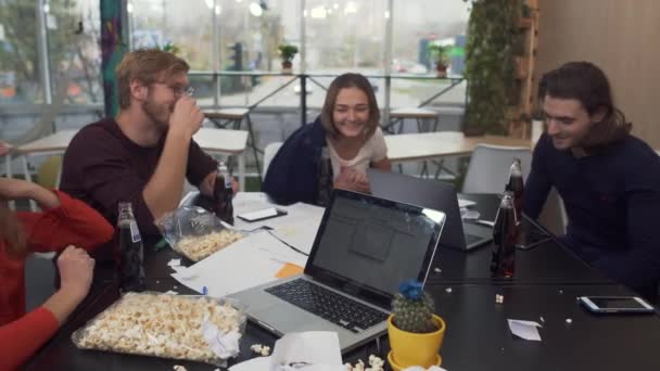 Cinq collègues divers dans l'humeur joyeuse cliquetis verres avec pepsi tout en célébrant quelque chose dans le bureau moderne 