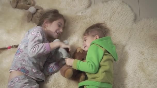 Syskon som rullande på fluffiga mattan. Bror och syster har en rolig. Glada barn i helgen. Slow motion. — Stockvideo