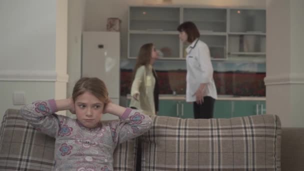 Mutter und ältere Tochter streiten sich zu Hause in der Küche. lillte Mädchen bedeckt ihre Ohren mit Händen. Probleme in Familienbeziehungen — Stockvideo