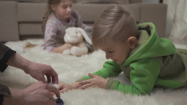 Двоє Милих Дітей Лежать Підлозі Пухнастому Килимі Граючи Свої Іграшки — стокове відео