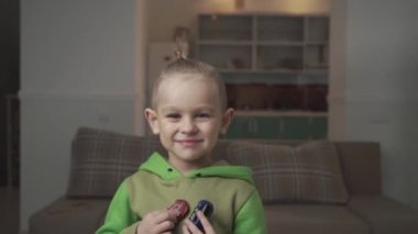 Biraz eğlence çocuk oyuncak arabalar ile poz şık bir saç modeli ile gülümseyen portresi.