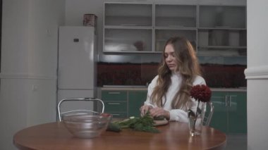 Kız kardeşler mutfaktaki masada sebze salatası pişirirler. Küçük kız kardeşi masada oturan ablası domates getiriyor ve o onu öper. Kız kardeş ilişkisi