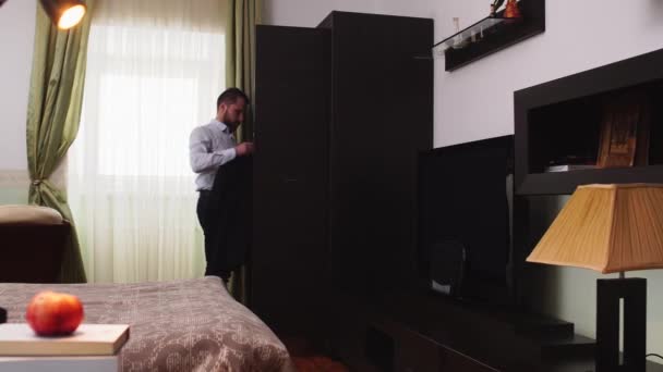 Стильный мужской костюм, стоящий у окна в спальне — стоковое видео