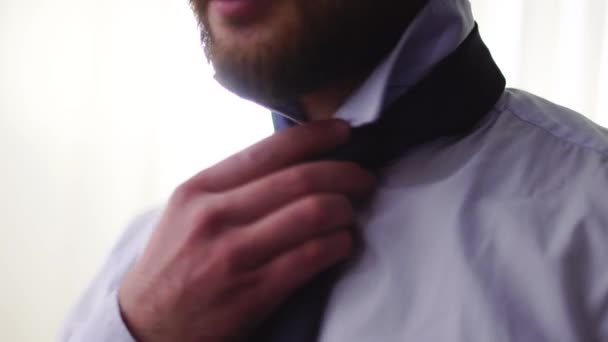 Bearded man hand tying a tie close up. Adult serious gentleman preparing for important meeting — Stock Video