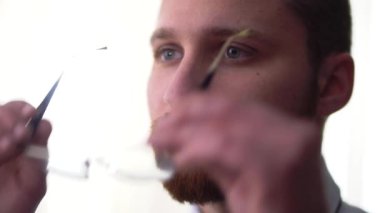 Gözlüklerini izole beyaz bir arka plan üzerinde siyah Halka'da koyarak ciddi sakallı adam portresi yakın çekim