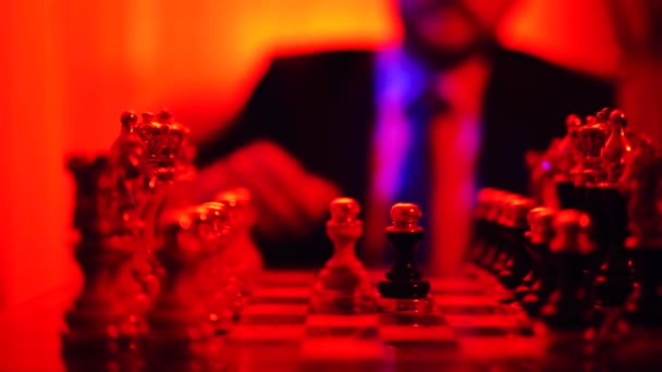 Close-up of the hand of a man in a business suit sitting on a blurred background playing chess. — Stock Video