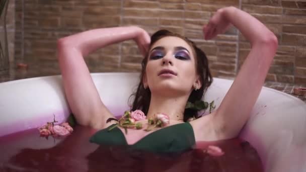 Молодая женщина с ярким макияжем принимает ванну наслаждаясь одиночеством — стоковое видео