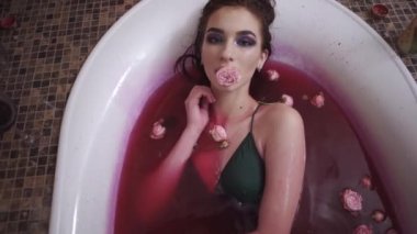 Kırmızı şarap ile banyoda yalan ağzına gül tutan kadar parlak yapmak olan kadın portresi. Bayan kamera arıyorum. Banyodaki şirin kız rahatlatıcı. Ağır çekim.