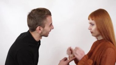 Kızgın agresif adam uzun kızıl saçlı güzel kız bağırıyor. Kadın kapatmak onun yüz ve kulaklar, o bu kötü kelimeler dinle değil.