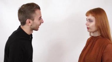 Kızgın agresif adam uzun kızıl saçlı güzel kız bağırıyor. Kadın kapatmak onun yüz ve kulaklar, o bu kötü kelimeler dinle değil.
