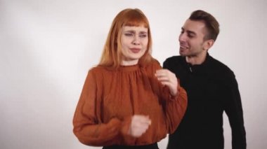 Saldırgan şiddet genç adam yakaladı kadının saç ve kız, bağır, uzun kızıl saçlı erkek deneyin kendini korumak için.