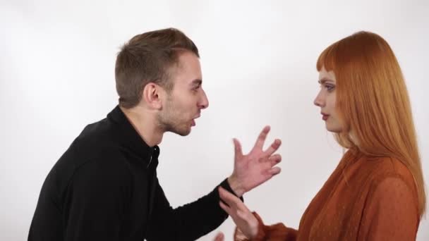 Angry aggresive man yelling at wife and show her his fist, woman raise her hand, push him with hand showing that guy must stop violence. — Stock Video